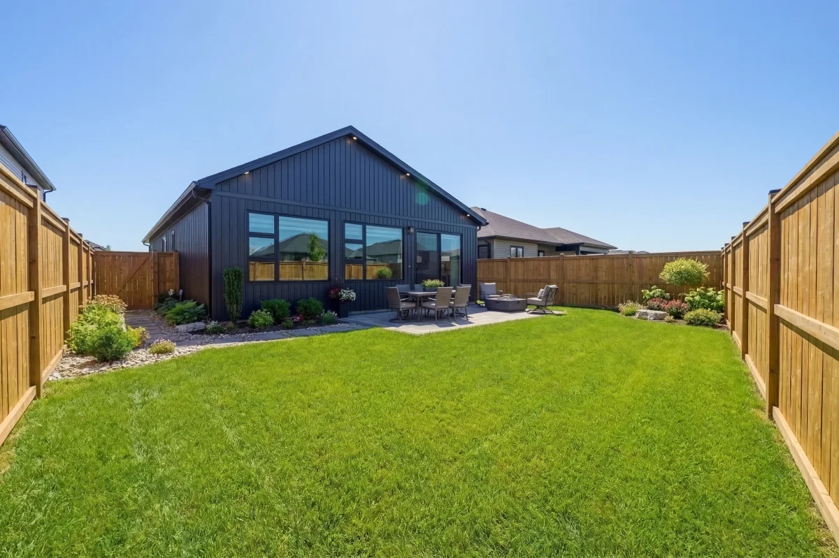Lot 52 Sheldabren backyard elevation with black board-and-batten cladding and landscaped yard in Ausable Bluffs Ailsa Craig Ontario