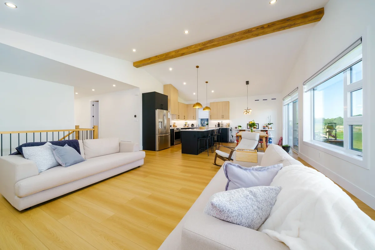 Lot 52 Sheldabren open-concept living room with exposed beam vaulted ceiling and oak floors in Ausable Bluffs Ailsa Craig Ontario