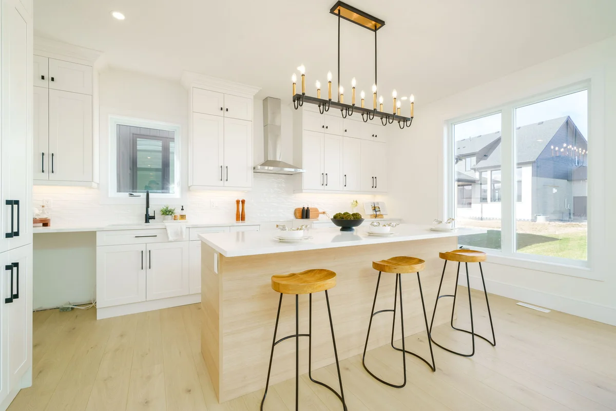 Starlit Homes white shaker kitchen with quartz island and industrial chandelier in Ailsa Craig Ontario