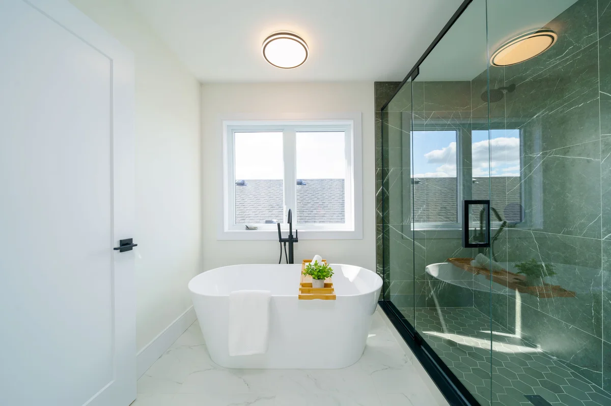 Starlit Homes freestanding soaker tub with marble tile and glass shower enclosure in Ailsa Craig Ontario