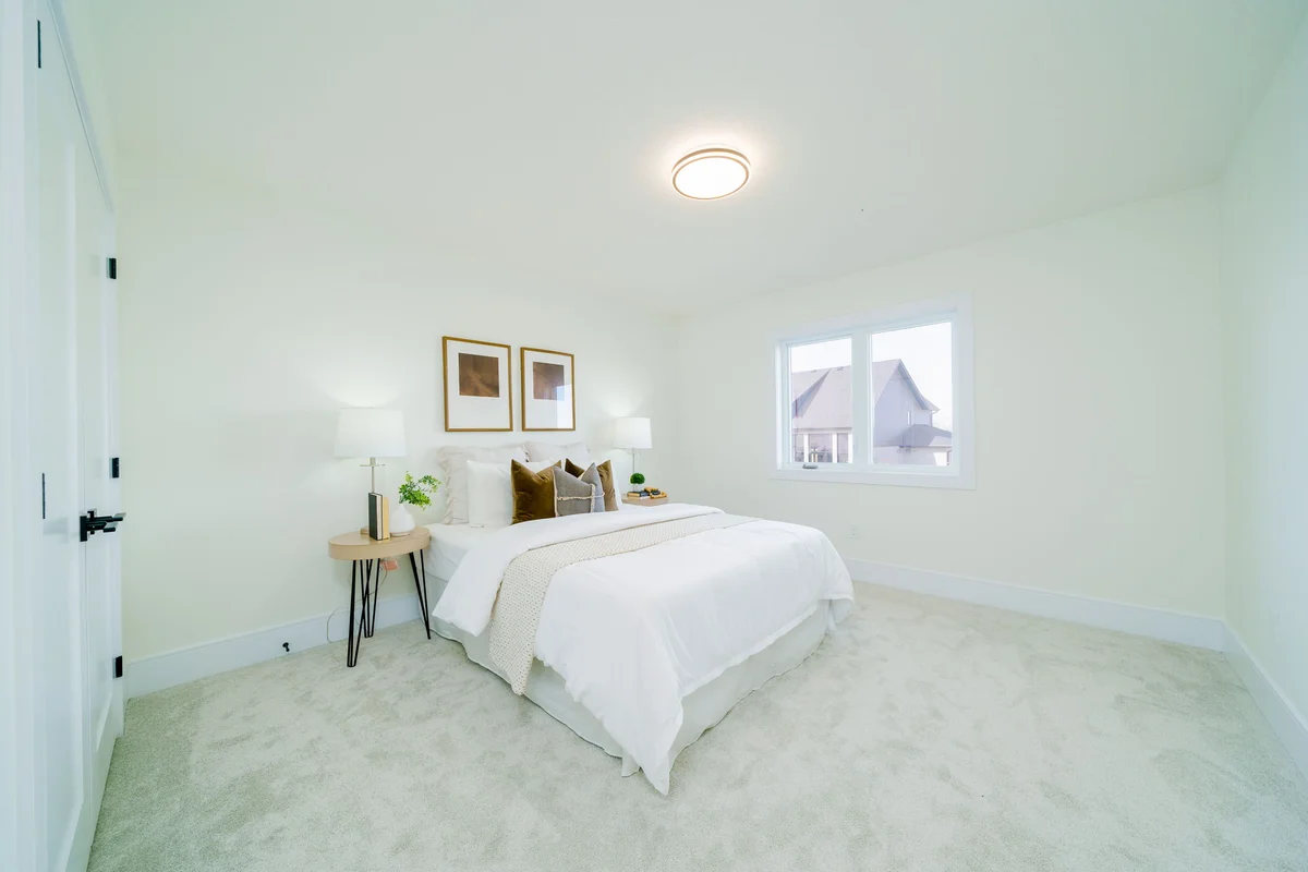 Starlit Homes guest bedroom with accent pillows and warm lighting in custom home Ailsa Craig Ontario